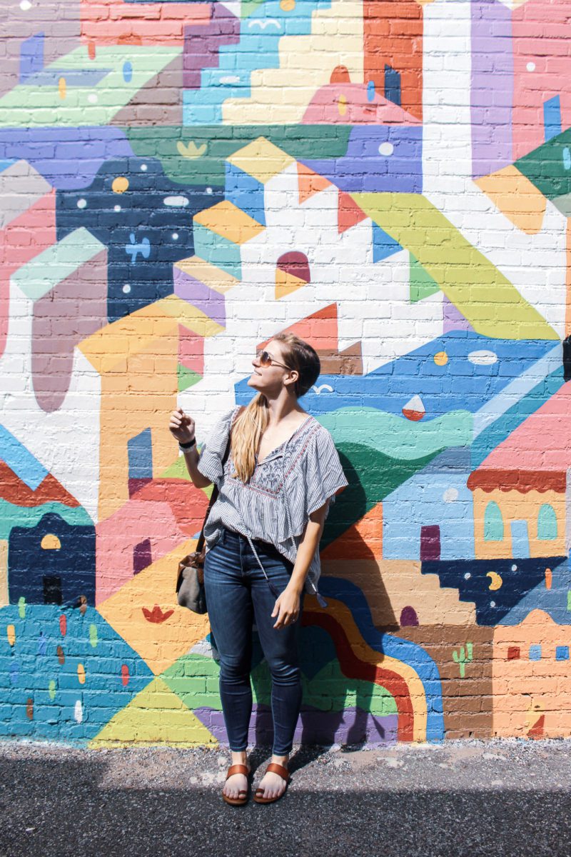 girl standing in front of okc plaza wall