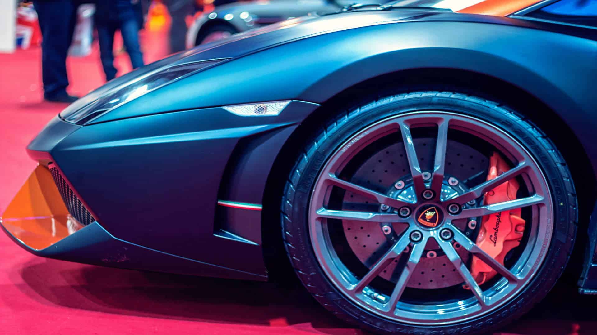 Close-up of a luxury sports car wheel with red brake caliper for catalytic converter suppliers