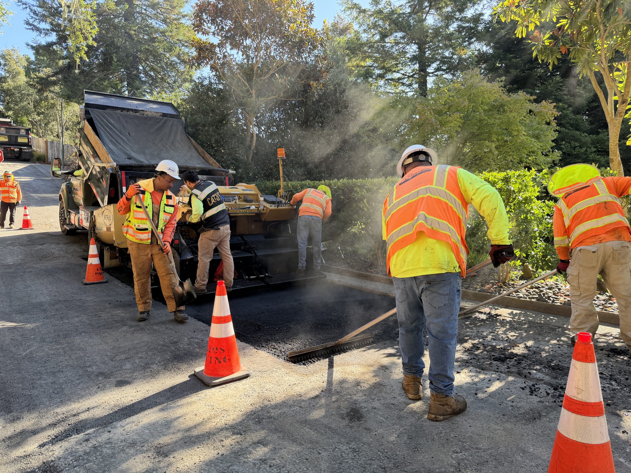 asphalt crew repairing patch