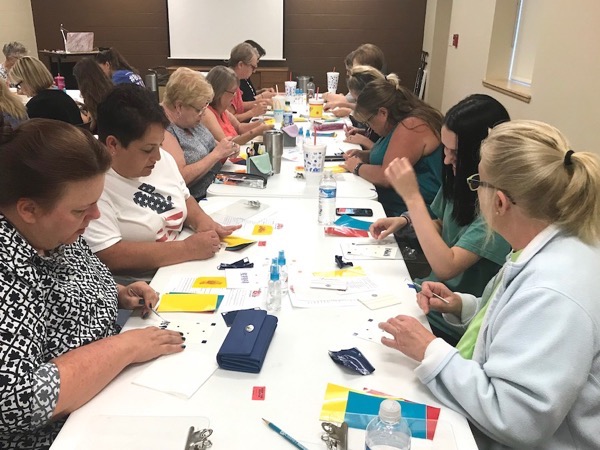 Group of students making layered adhesive vinyl decals during craft class