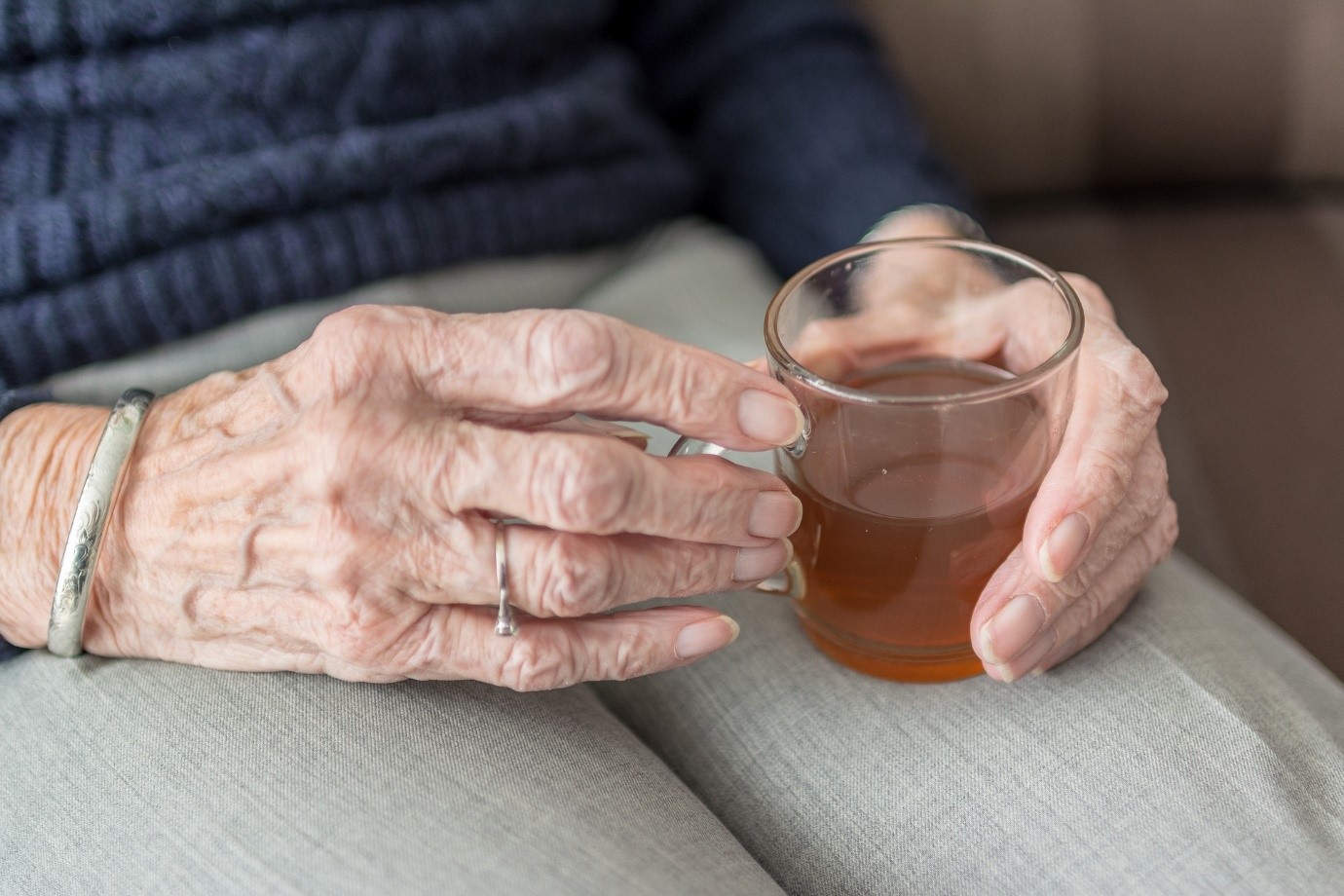 elderly hands holding a teacup