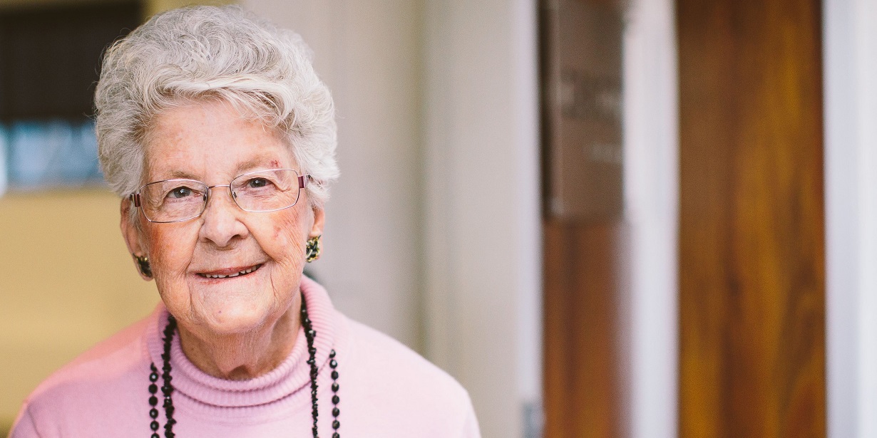 A senior woman looks directly at the camera