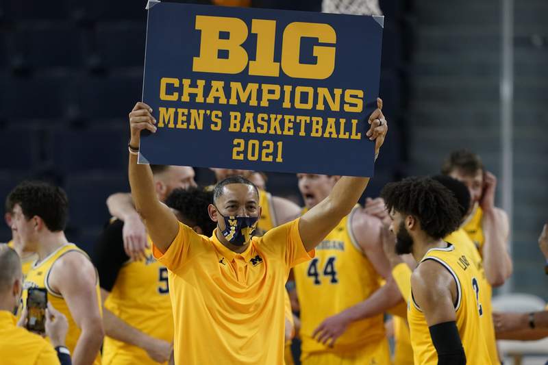 Big Ten Basketball Coach of the Year, Juwan Howard, hoists champions banner.