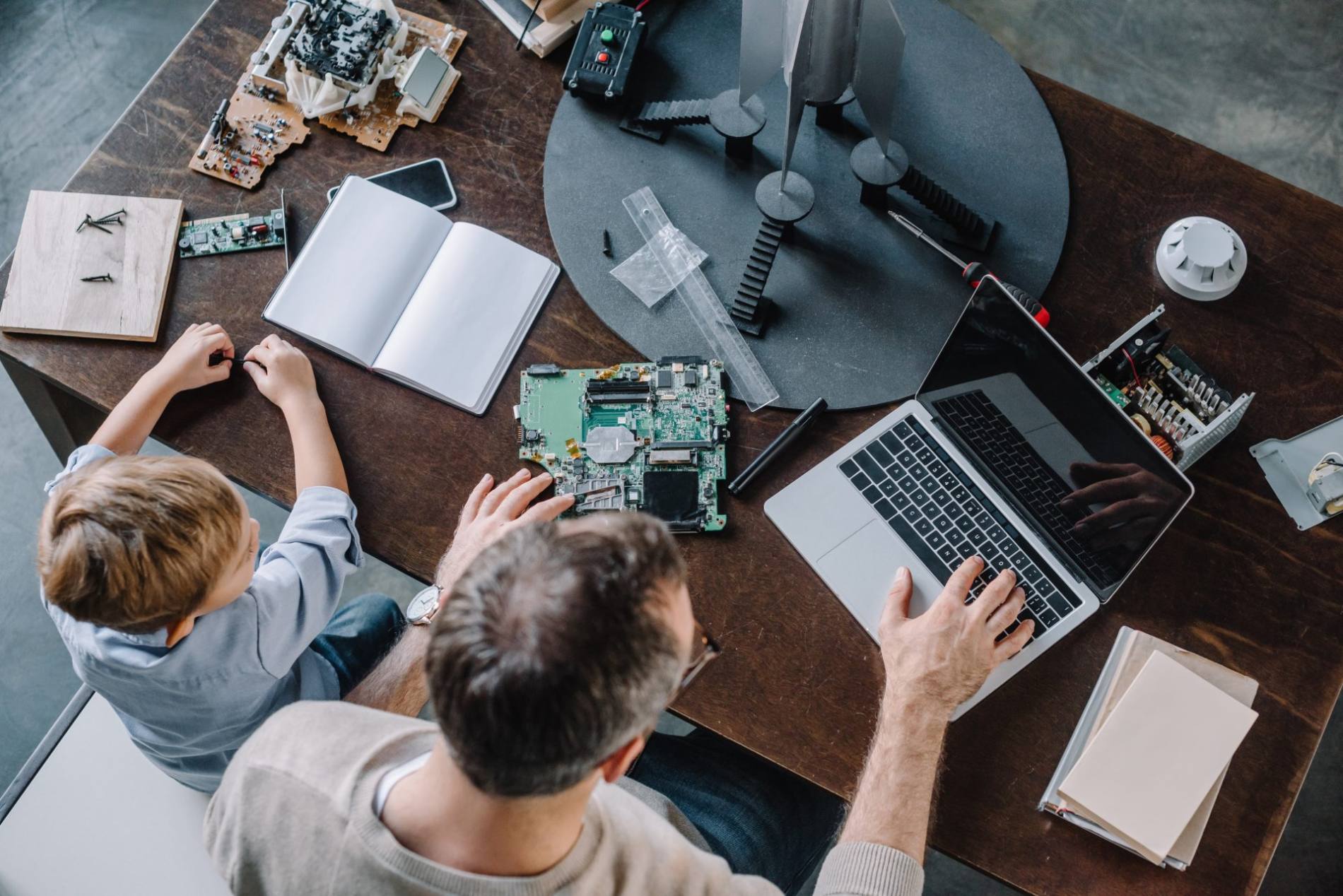 overhead-view-of-father-and-son-using-laptop-for-m-2023-11-27-05-01-39-utc