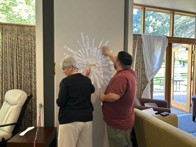 two people taping word to a wall