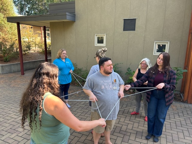 group working together to create a star pattern with a string