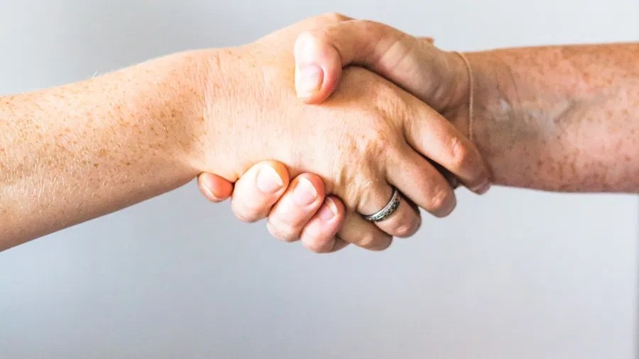 Close-up of two people shaking hands representing trust and connection