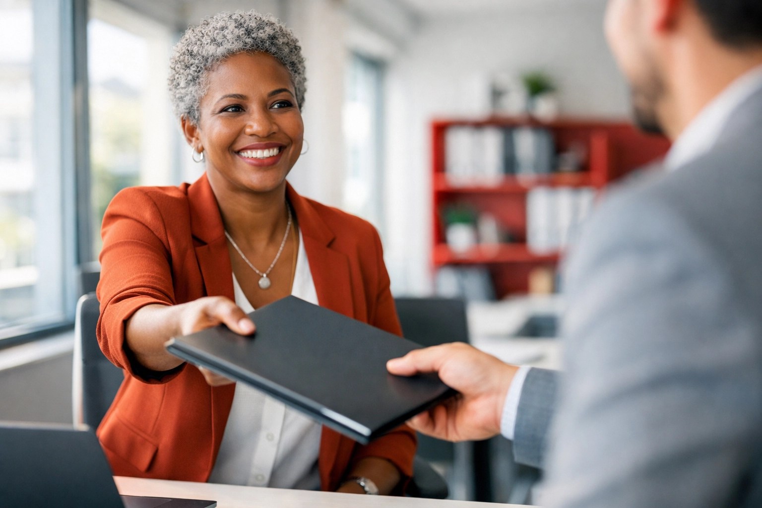 Non-profit executive director delegating tasks to a team member in a collaborative office.