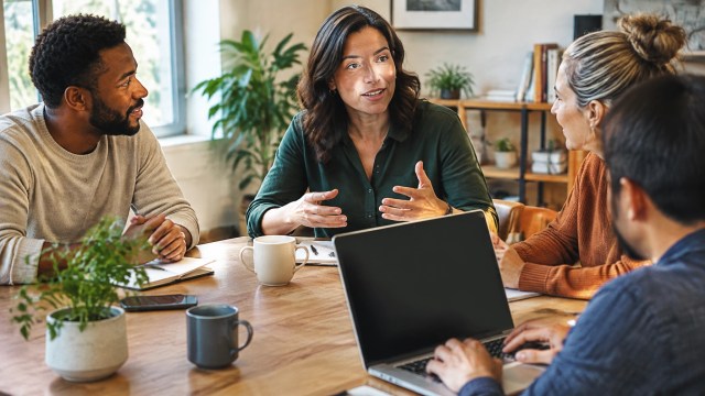 A business owner leading a meeting while colleagues listen and take notes.
