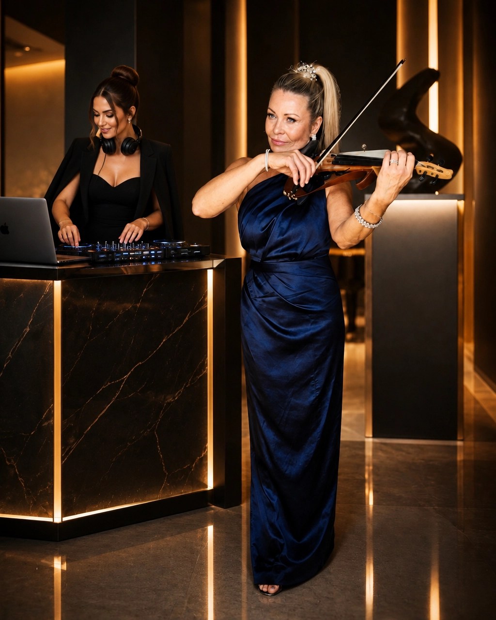 Carrie Caruso performing violin alongside a DJ at a sleek booth in an upscale venue