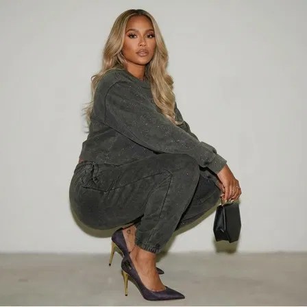 A confident woman models Marcella’s handcrafted Italian stiletto heels in deep violet with a gold heel, highlighting bold elegance.