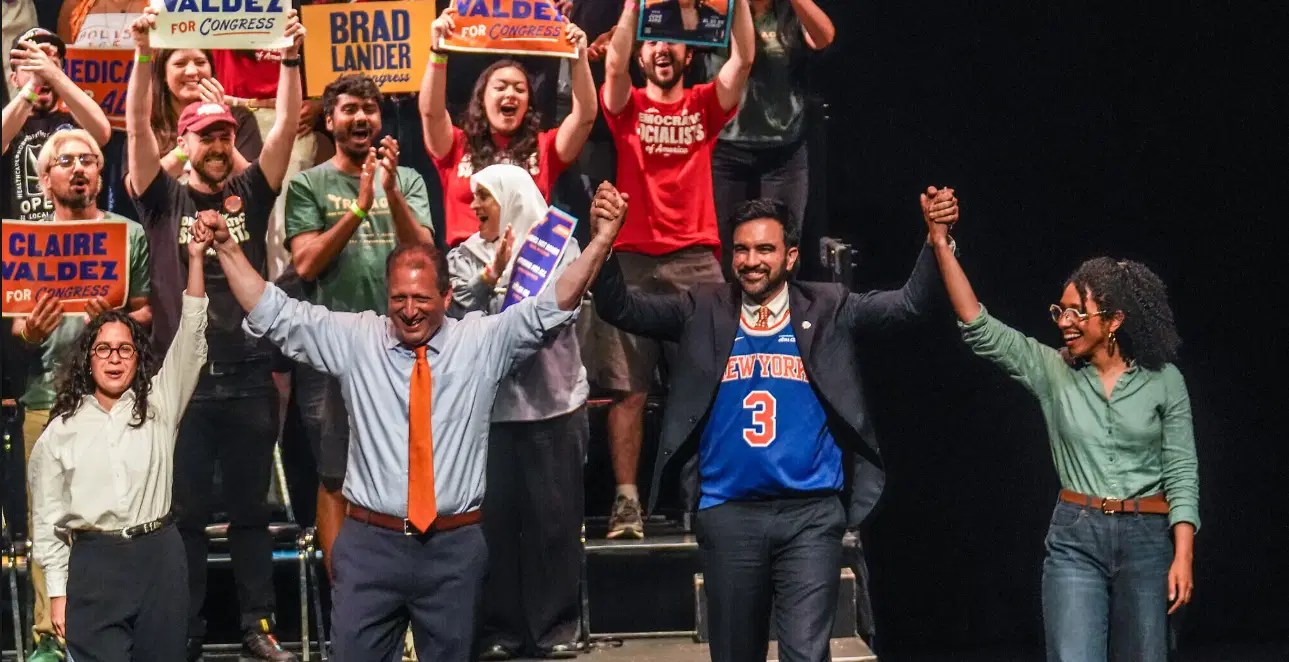 The NYCDSA team celebrating with signs for Claire Valdez, highlighting the political engagement necessary for cultural and economic shifts.