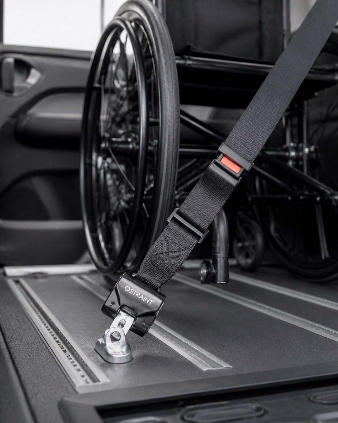 A professional close-up of a wheelchair tie-down system and safety belt.