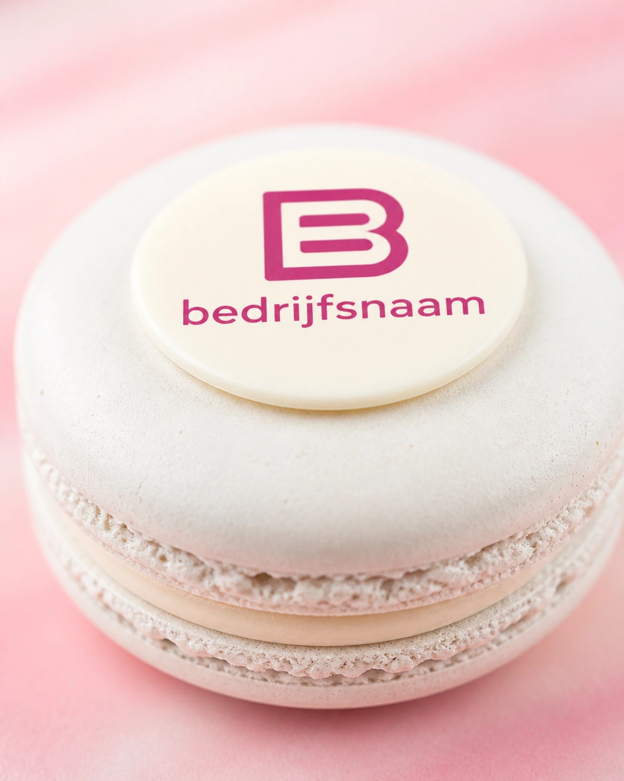 Macro-opname van een gepersonaliseerde macaron met een scherp wit chocolade-logo.