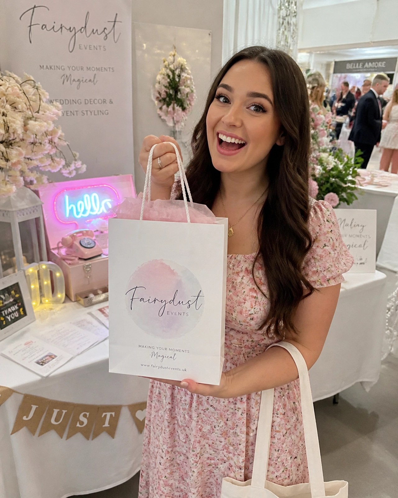 A bride-to-be holding a Fairydust Events goody bag at a bright, airy wedding fayre.