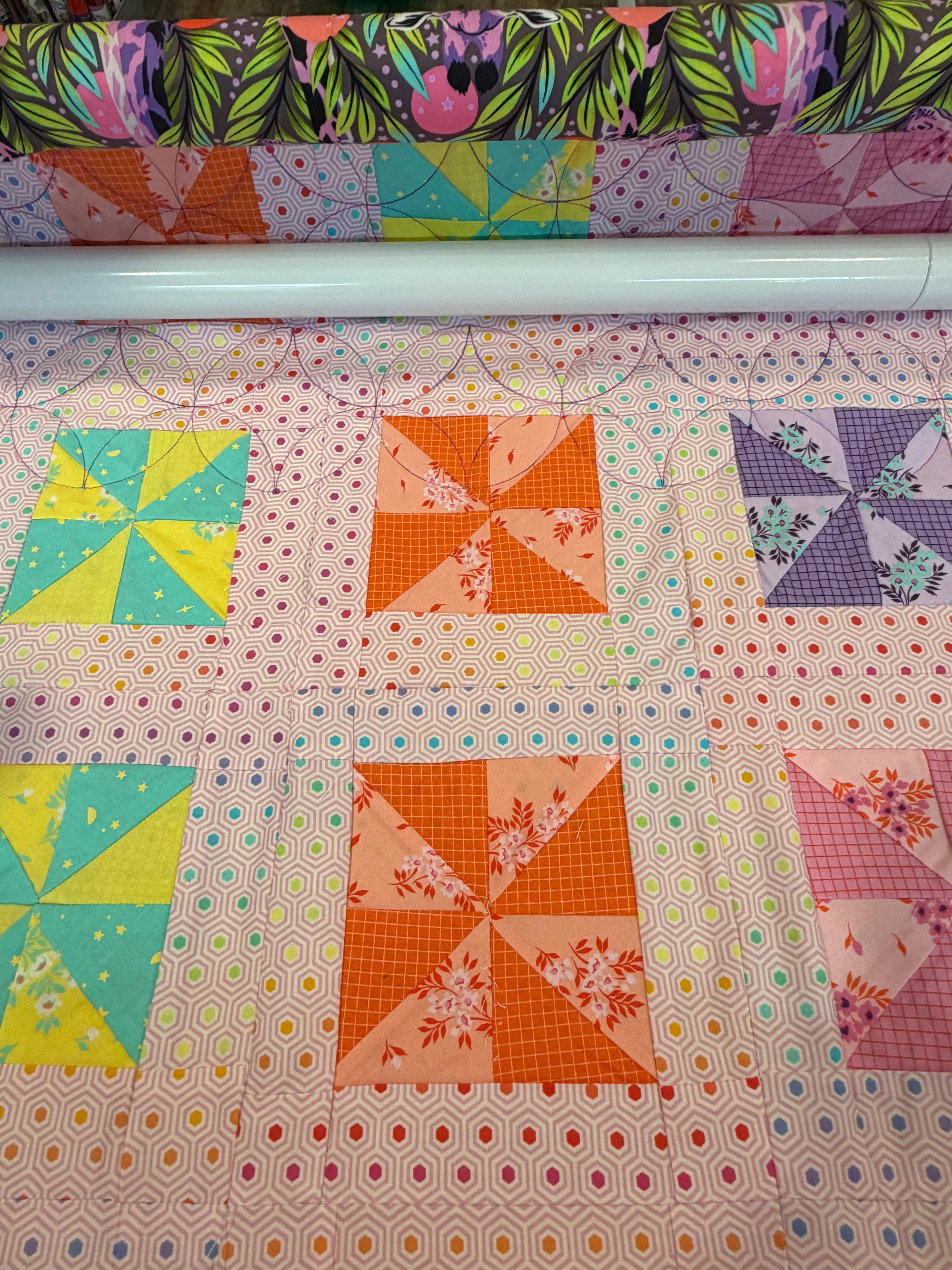A quilt loaded on the longarm frame in the studio.