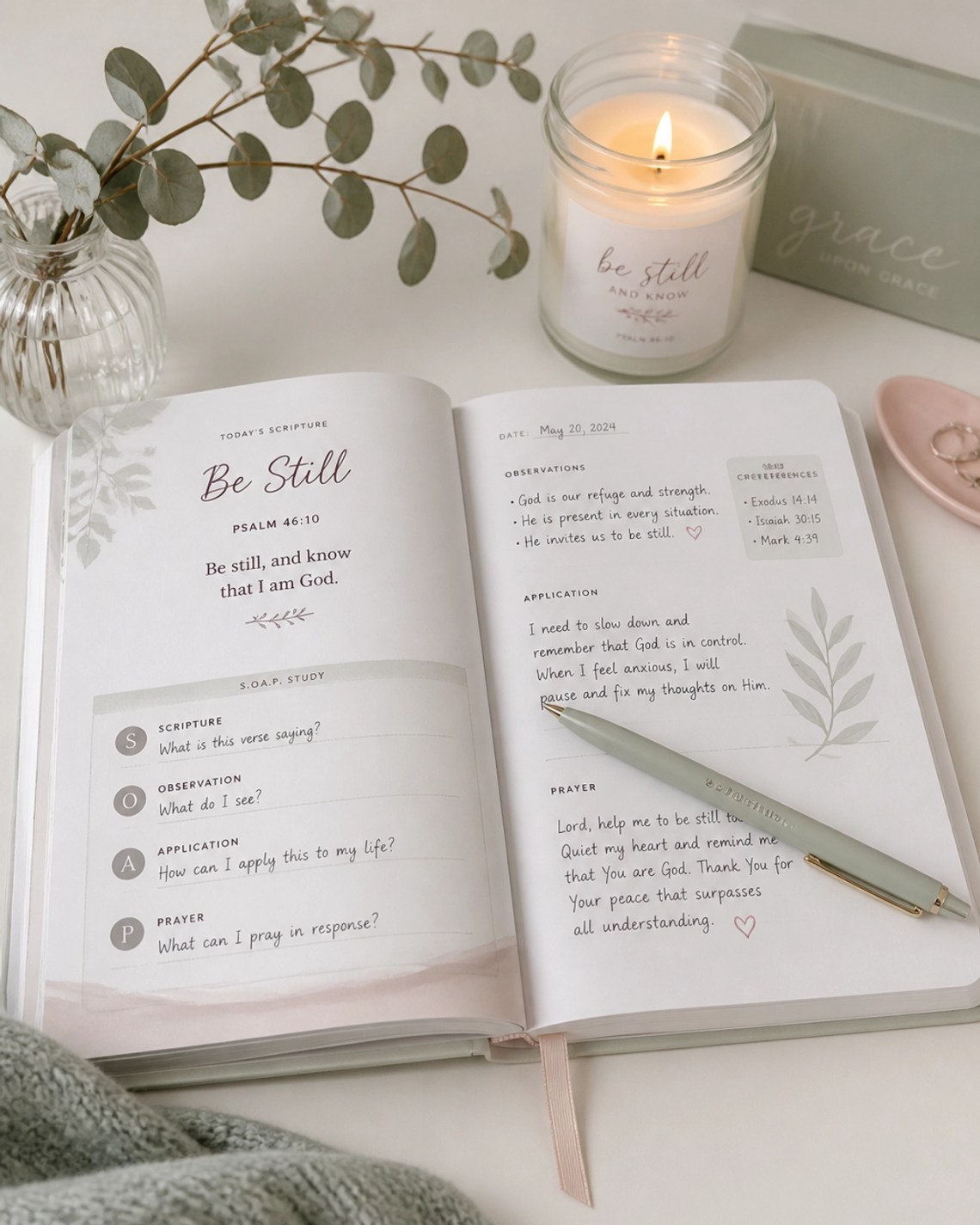 A Bible study setup with a lit candle and a misty sage pen.