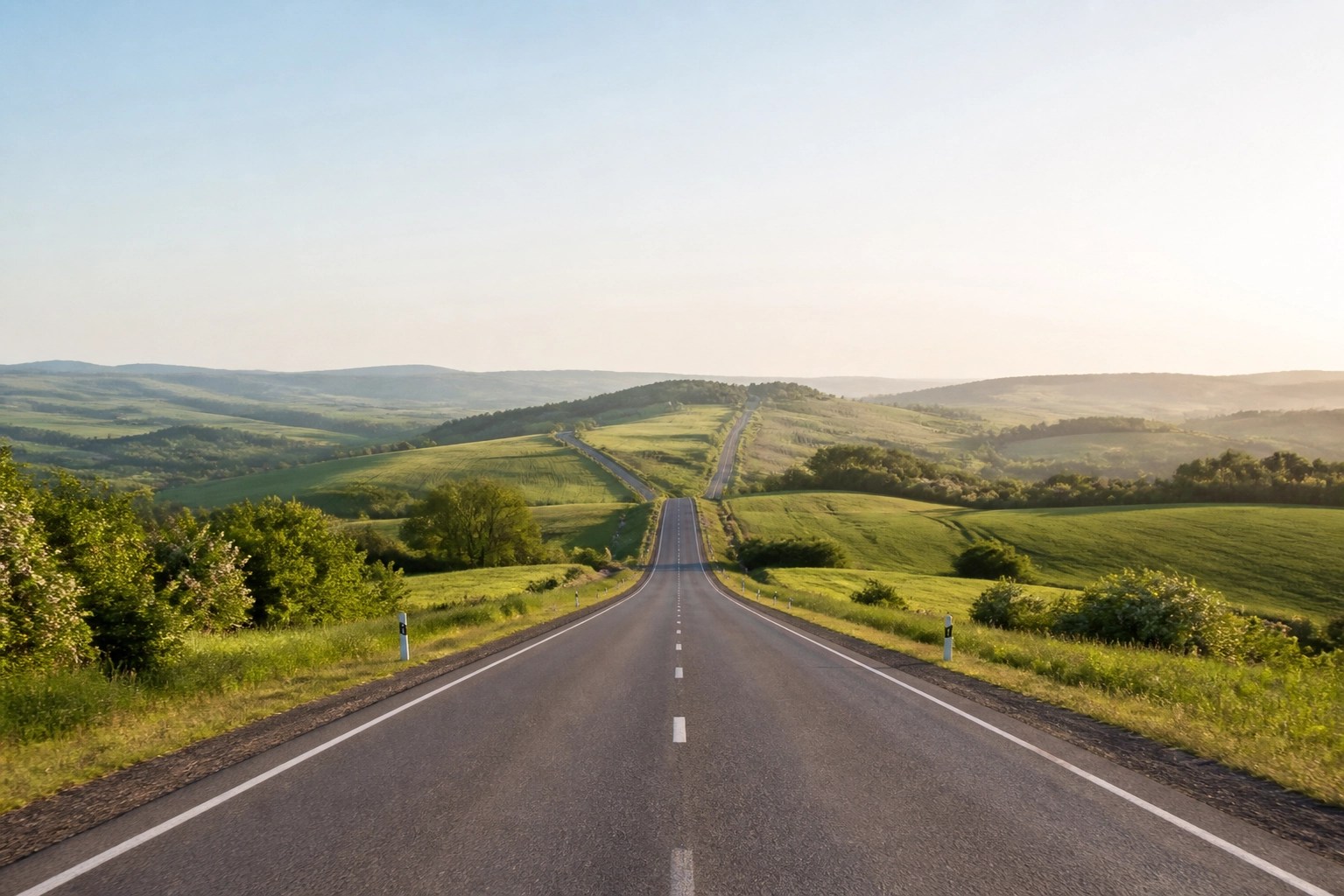 Long road through rural hills representing the journey to healthcare access for remote residents.