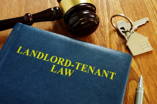 Gavel, house keys, and landlord-tenant law materials illustrating the transition from notice to court action