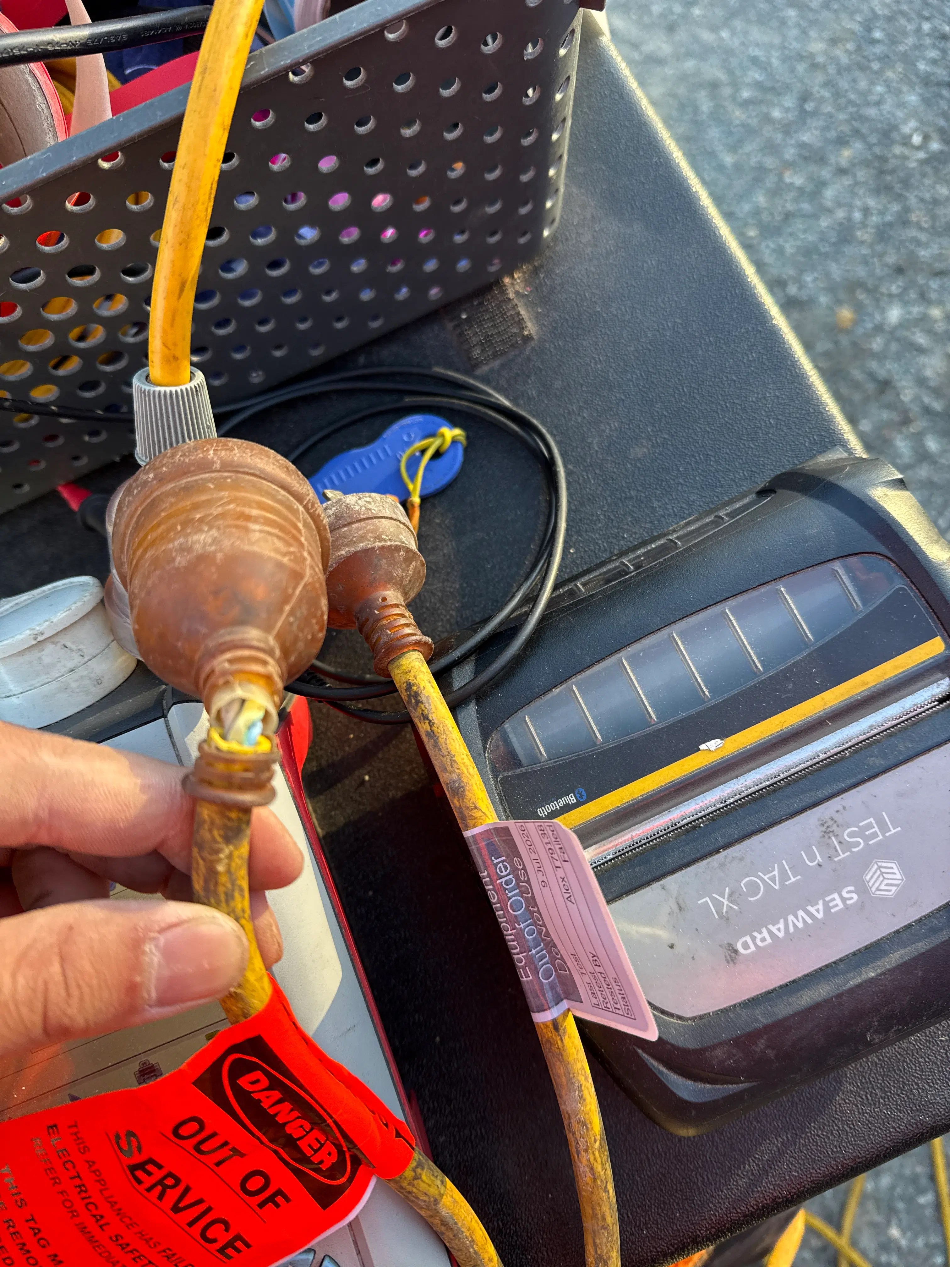 Damaged extension lead isolated with a red out-of-service safety tag