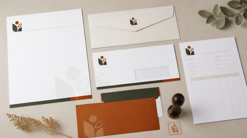 Branded letterheads and envelopes arranged in a clean fall-themed flat-lay