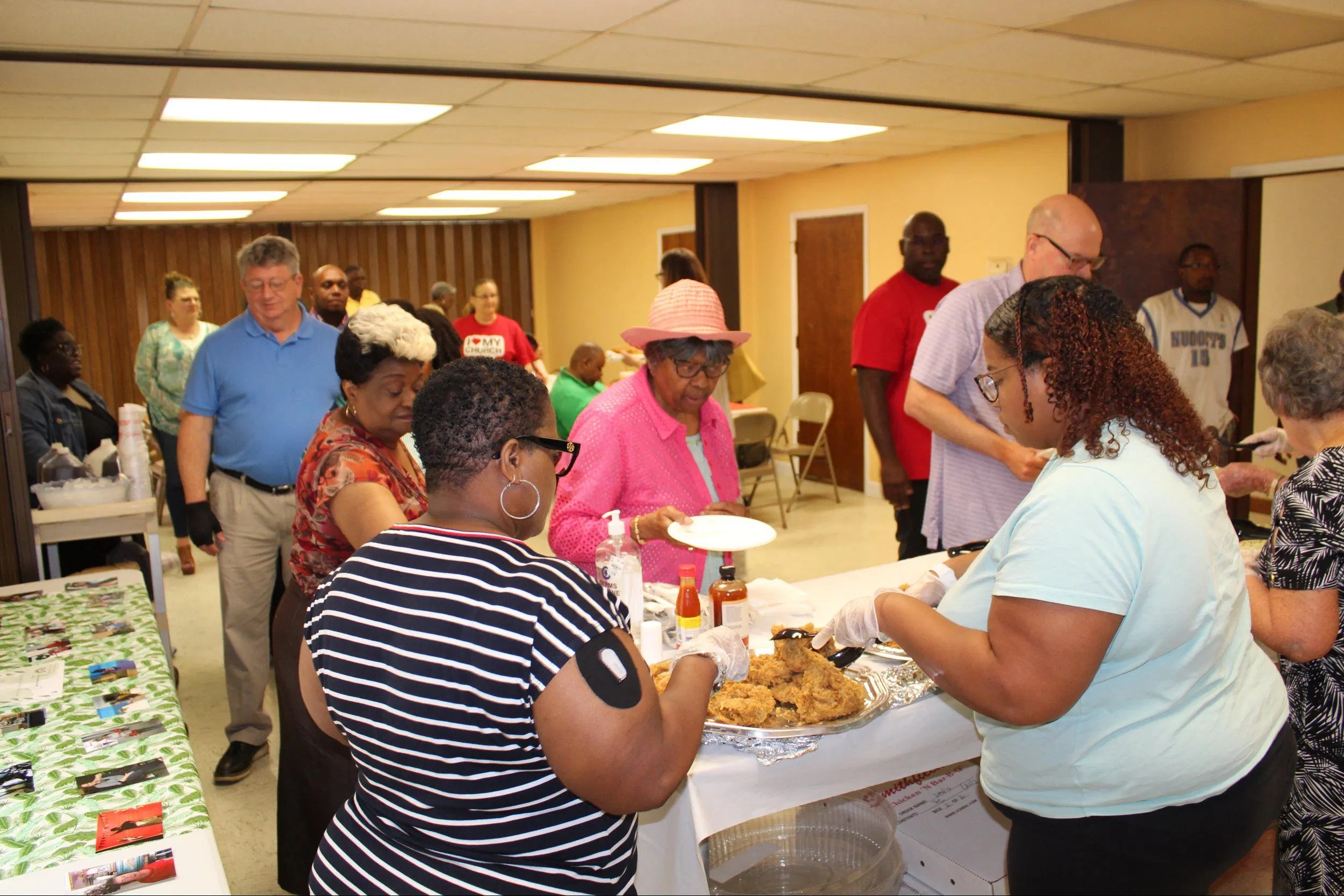 Church members gathered in the fellowship hall sharing a meal and conversation, reflecting a commitment to fellowship and hospitality.