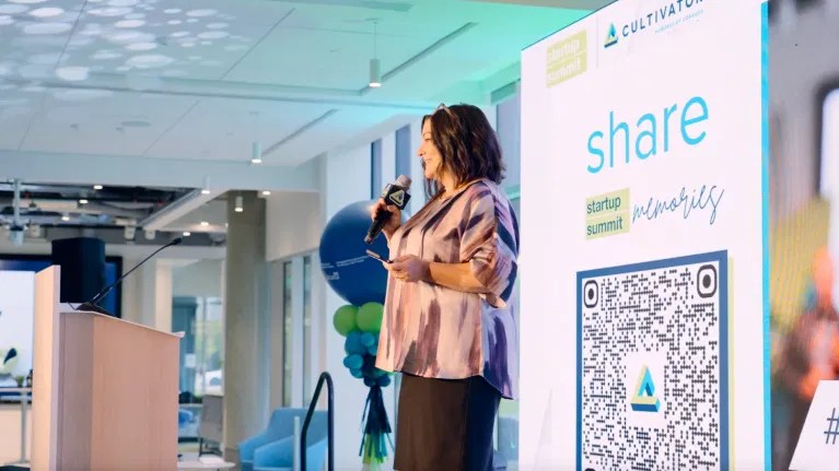 Event speaker beside a QR code display inviting guests to share photos