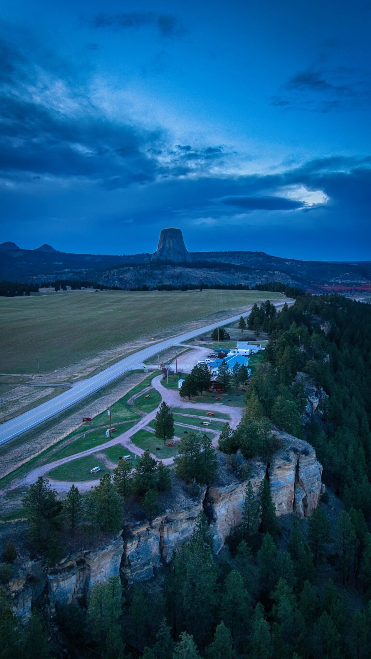 A high-resolution aerial view of a property at twilight, demonstrating the use of sky replacement and light styling.