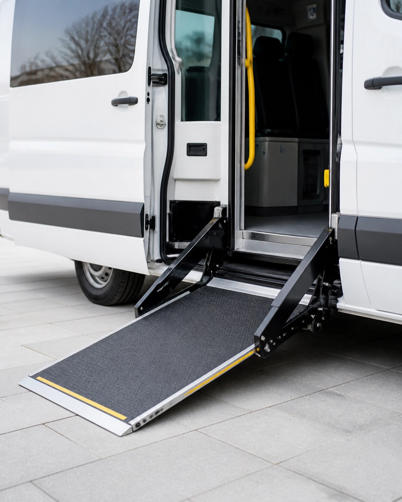 A modern wheelchair ramp extending from the side of a professional transport vehicle