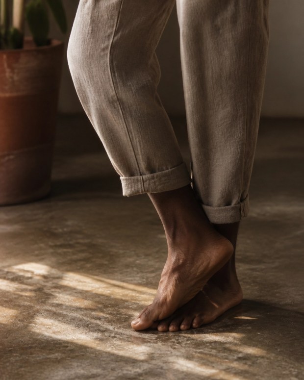 Grounded feet and one ankle gently rotating on a textured floor
