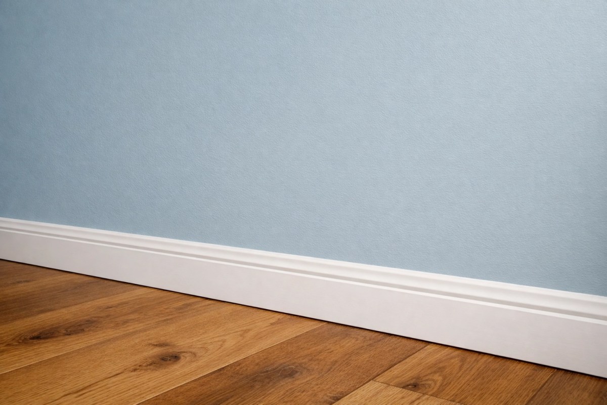 Professionally painted lounge room featuring pale earthy blue walls and warm timber flooring.