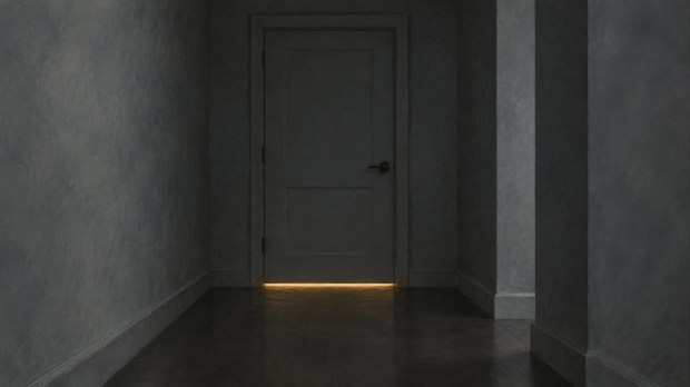 A closed interior door with a thin line of light beneath it