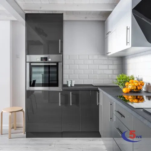 A sleek modern kitchen installation featuring charcoal cabinets and precise white tile splashback, showcasing C5ive's attention to detail.