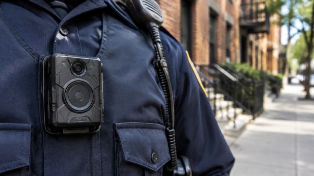 A body-worn camera on a generic police uniform, representing evidence and transparency in use-of-force reviews