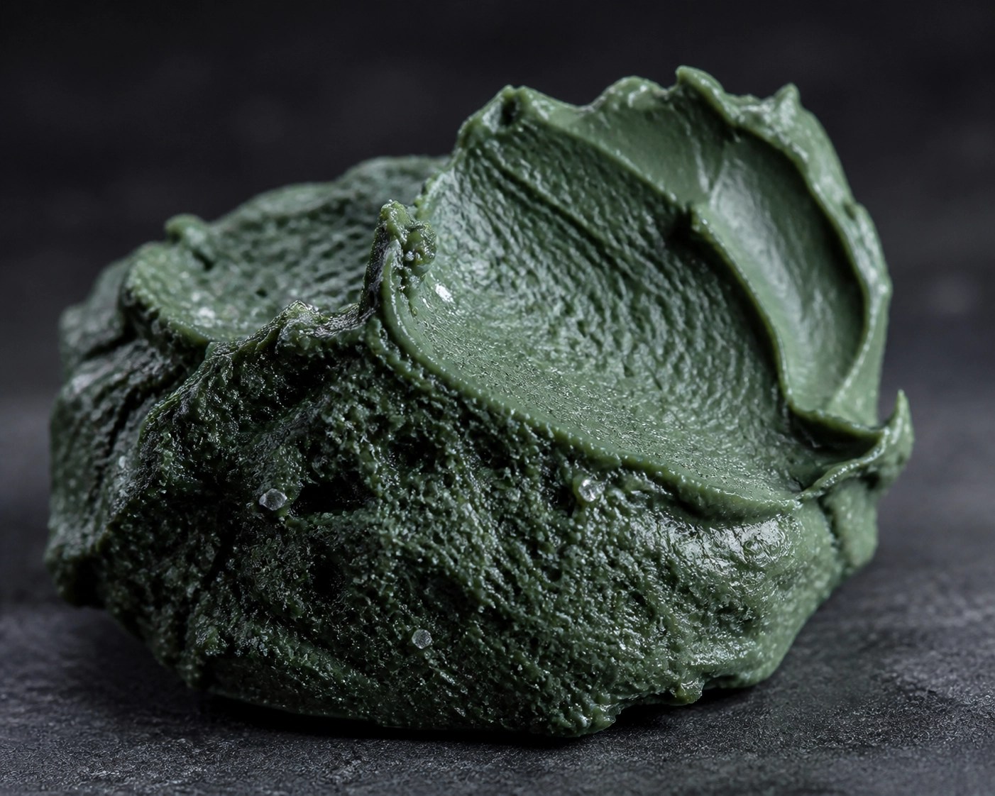 Close-up of rich French Green Clay texture showing natural minerals for deep cellular healing.
