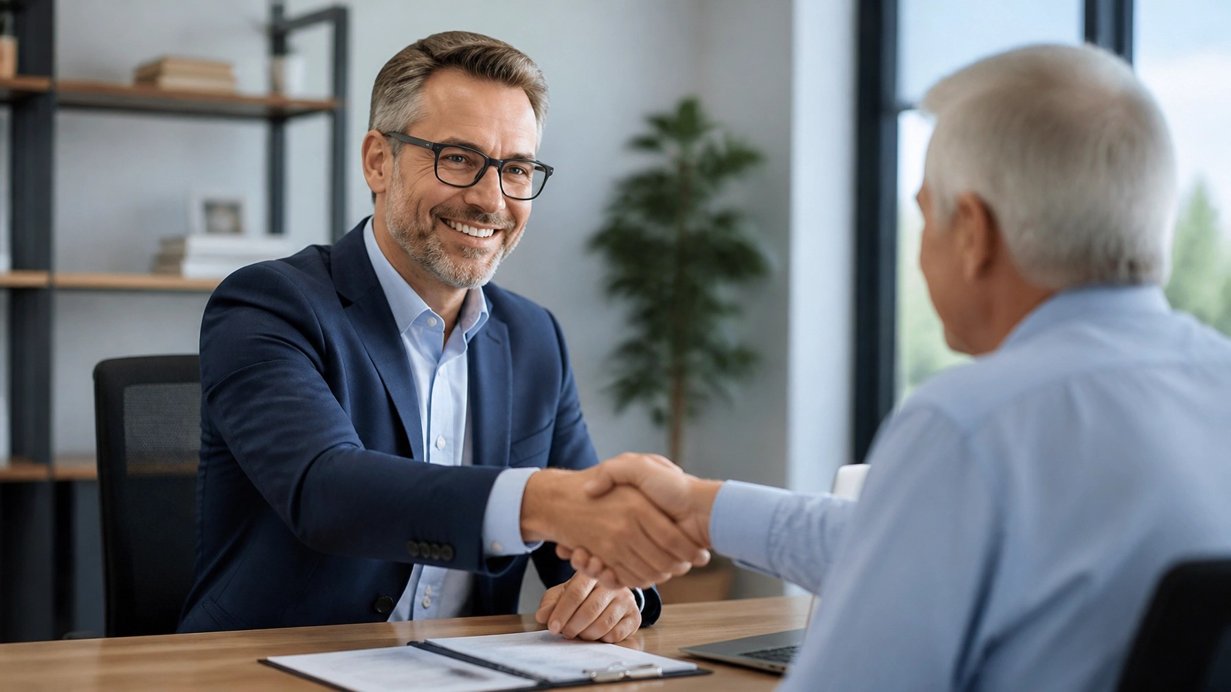A friendly insurance advisor shaking hands with a senior client, establishing a bond of trust.
