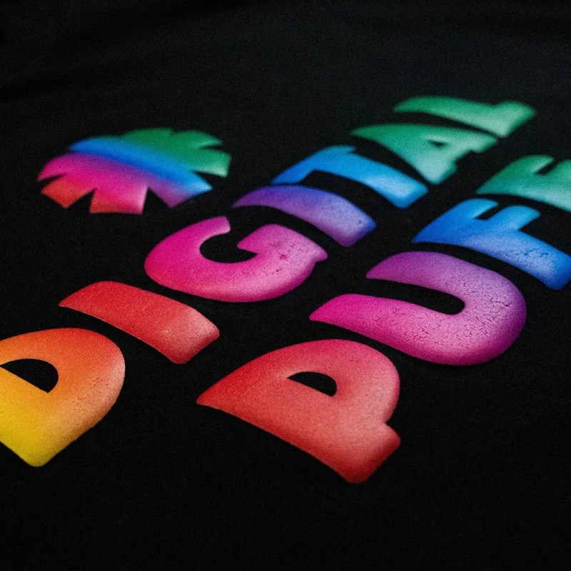 Close-up of a vibrant digital puff print showing raised, full-color detail on a black garment