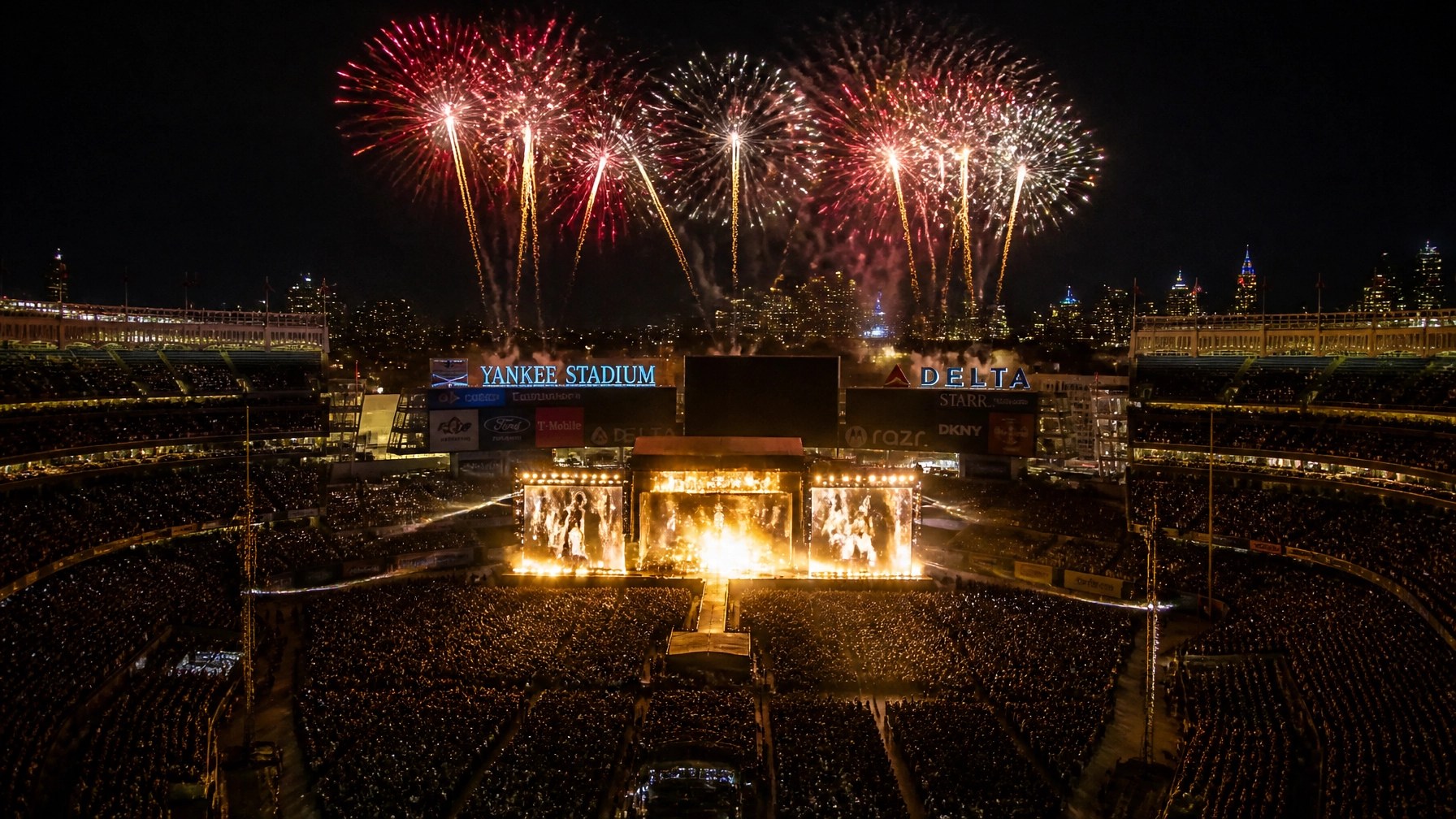 Wide shot of Yankee Stadium during the grand finale with fireworks exploding in the sky above the Bronx