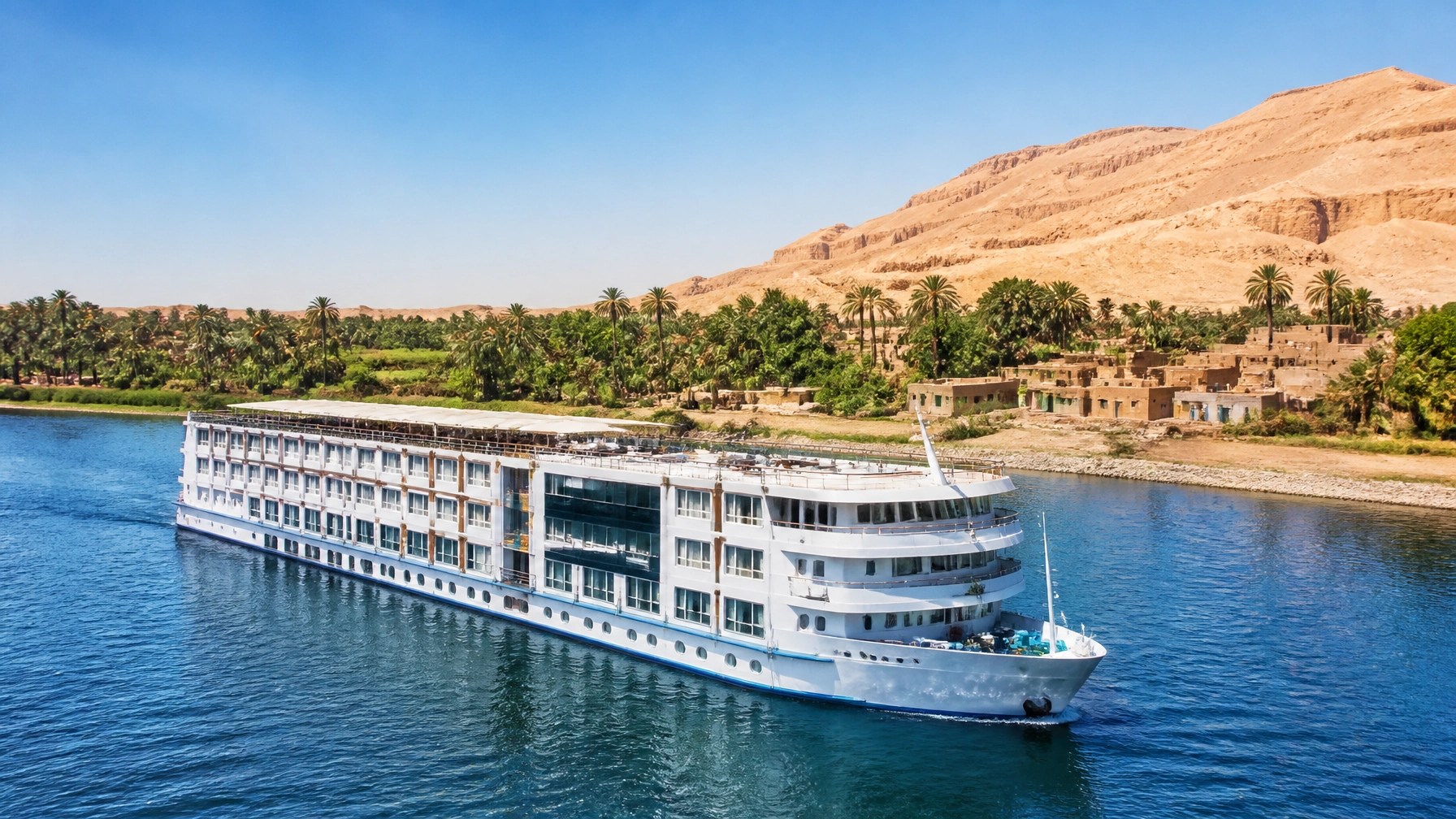 Elegant Nile cruise ship gliding past palms, desert and riverside villages