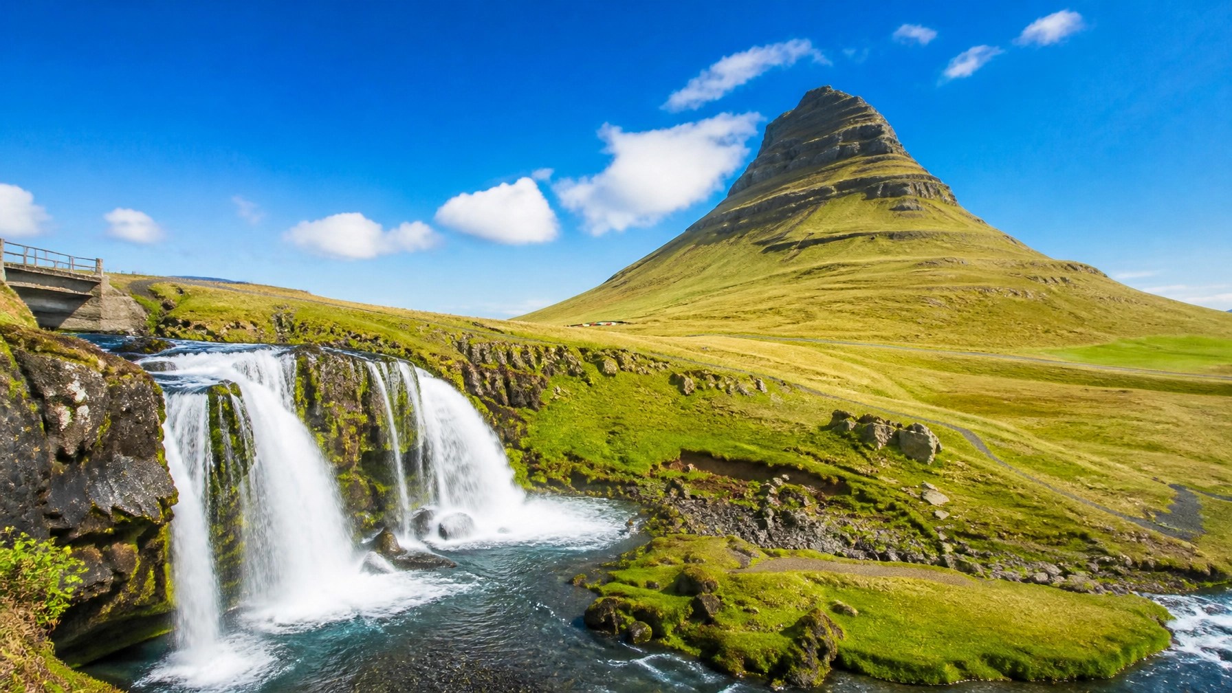 Stunning daytime landscape of Iceland with green mossy mountains and brilliant blue skies