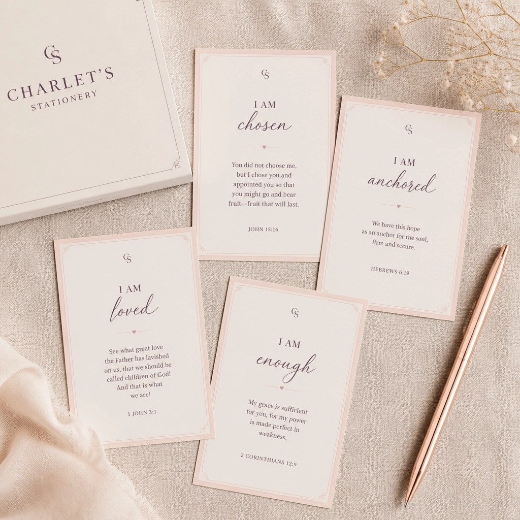 A high-end flat lay of faith-based affirmation cards and a rose gold pen