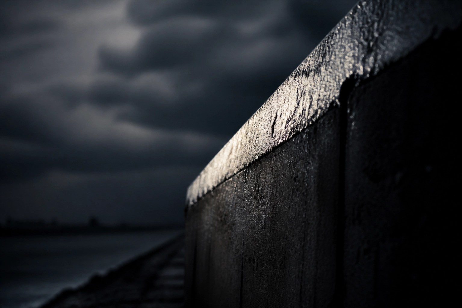 A weathered concrete barrier standing firm against a stormy sky, symbolizing cybersecurity resilience.