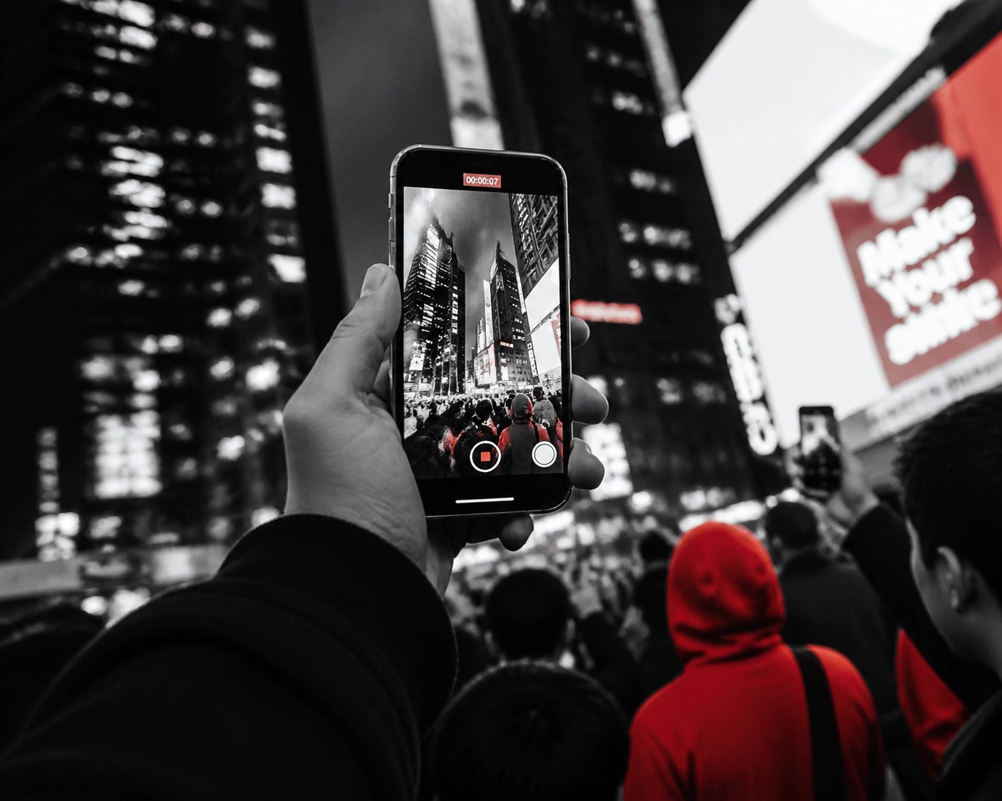 Smartphone recording an urban street scene illustrating viral news culture and community media.