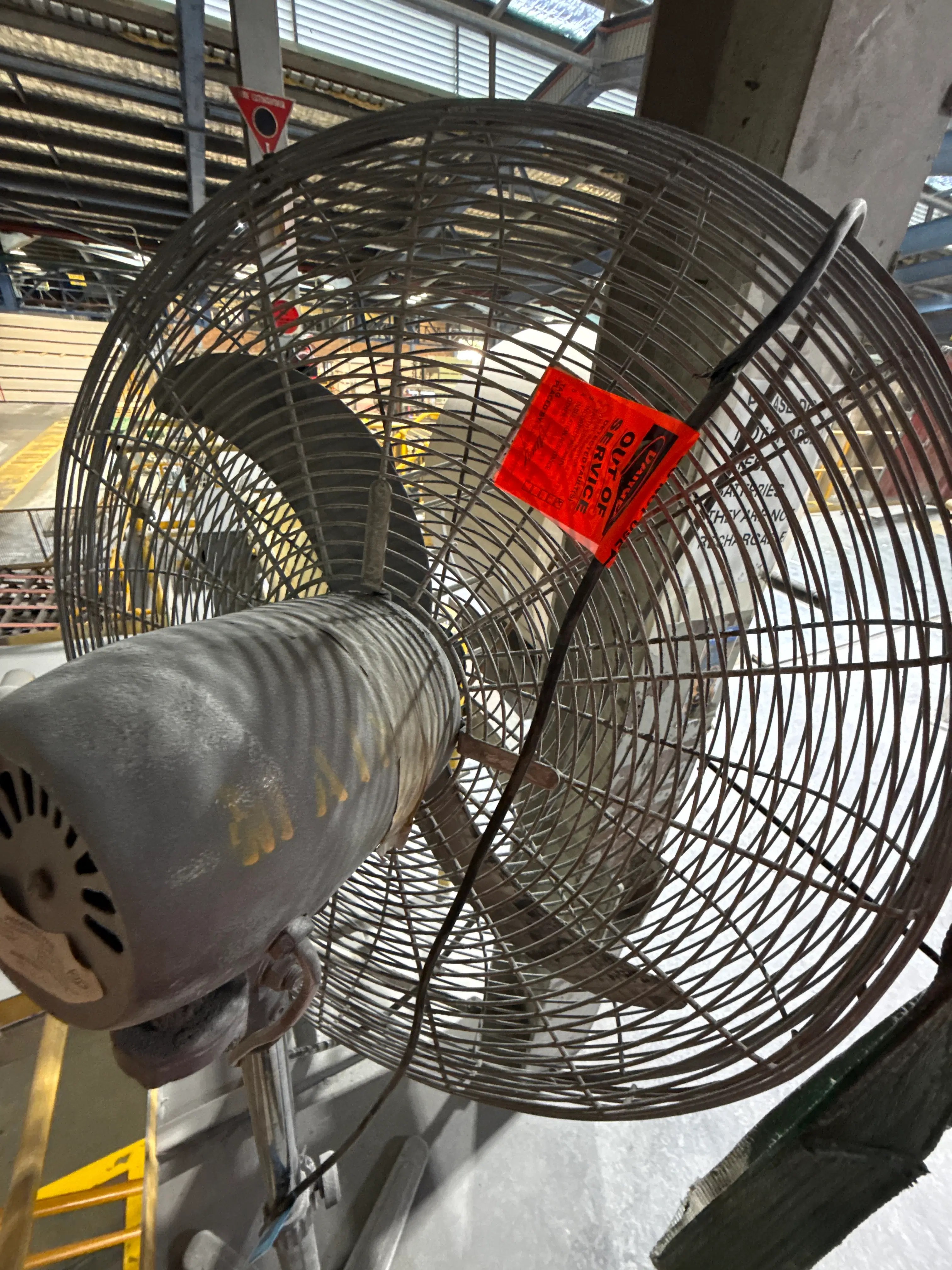 Industrial pedestal fan marked out of service with a red danger tag after failing a workplace safety inspection