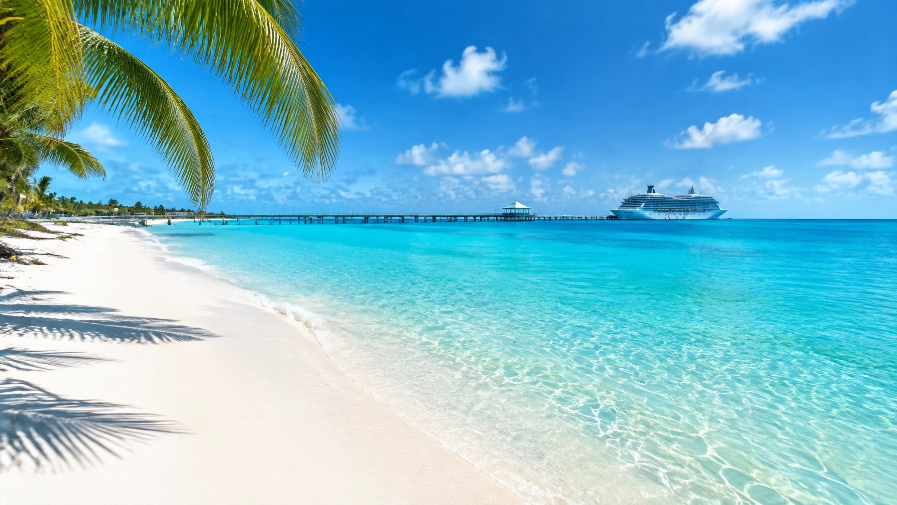 A quiet stretch of white sand and clear turquoise water at Grand Turk, with a cruise ship in the distance