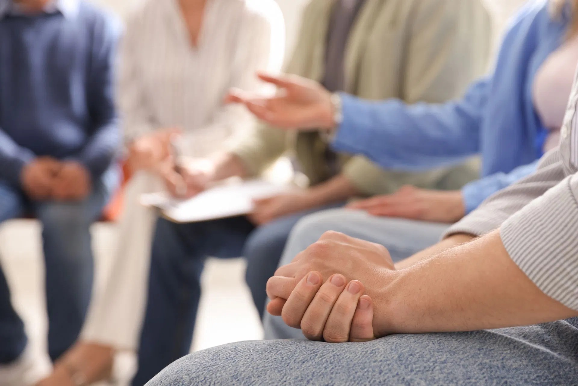 Hands resting together in a supportive counseling or wellness group