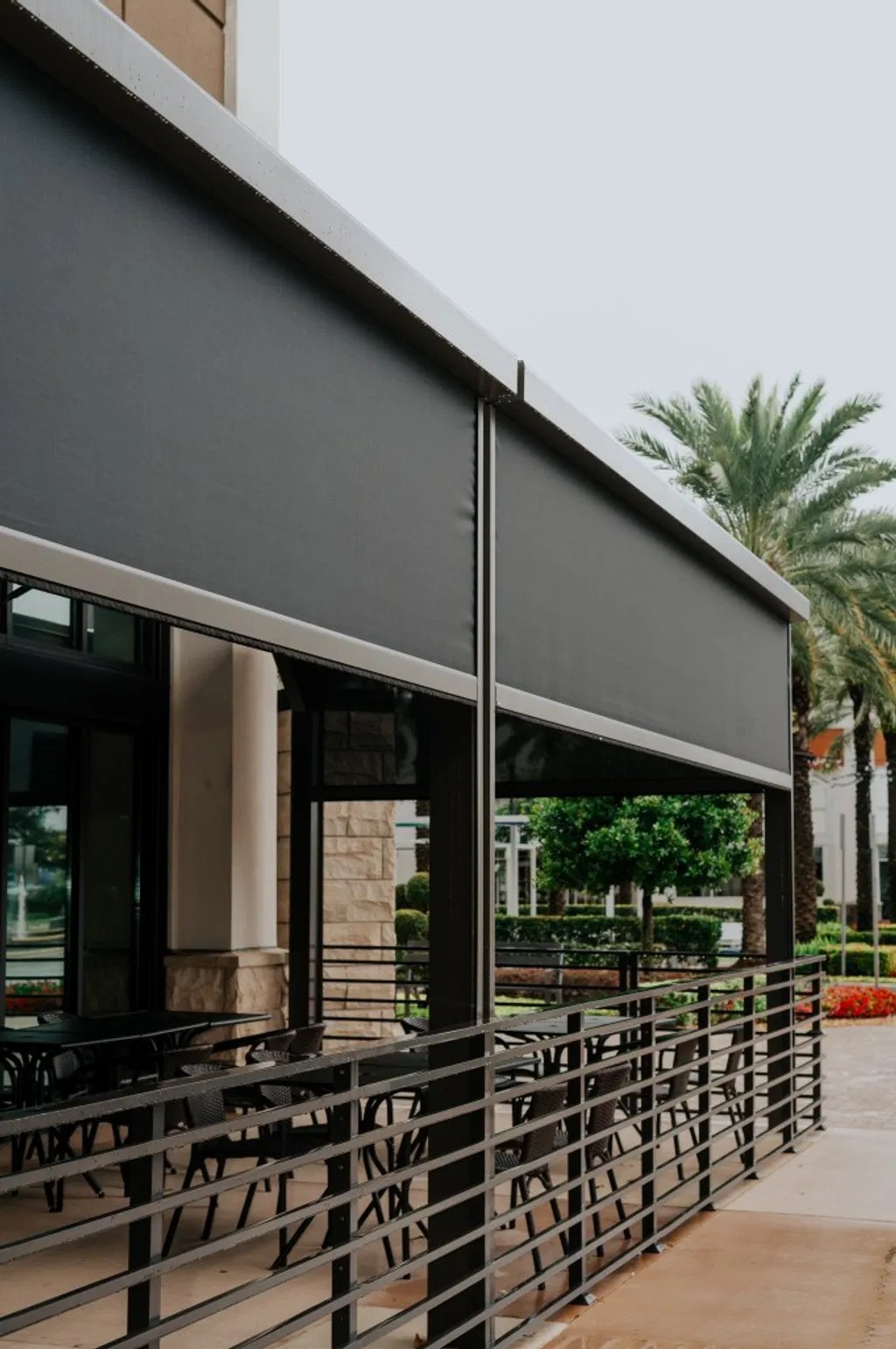 A custom-fitted motorized adjustable screen system on a modern patio, providing privacy and protection while maintaining airflow.