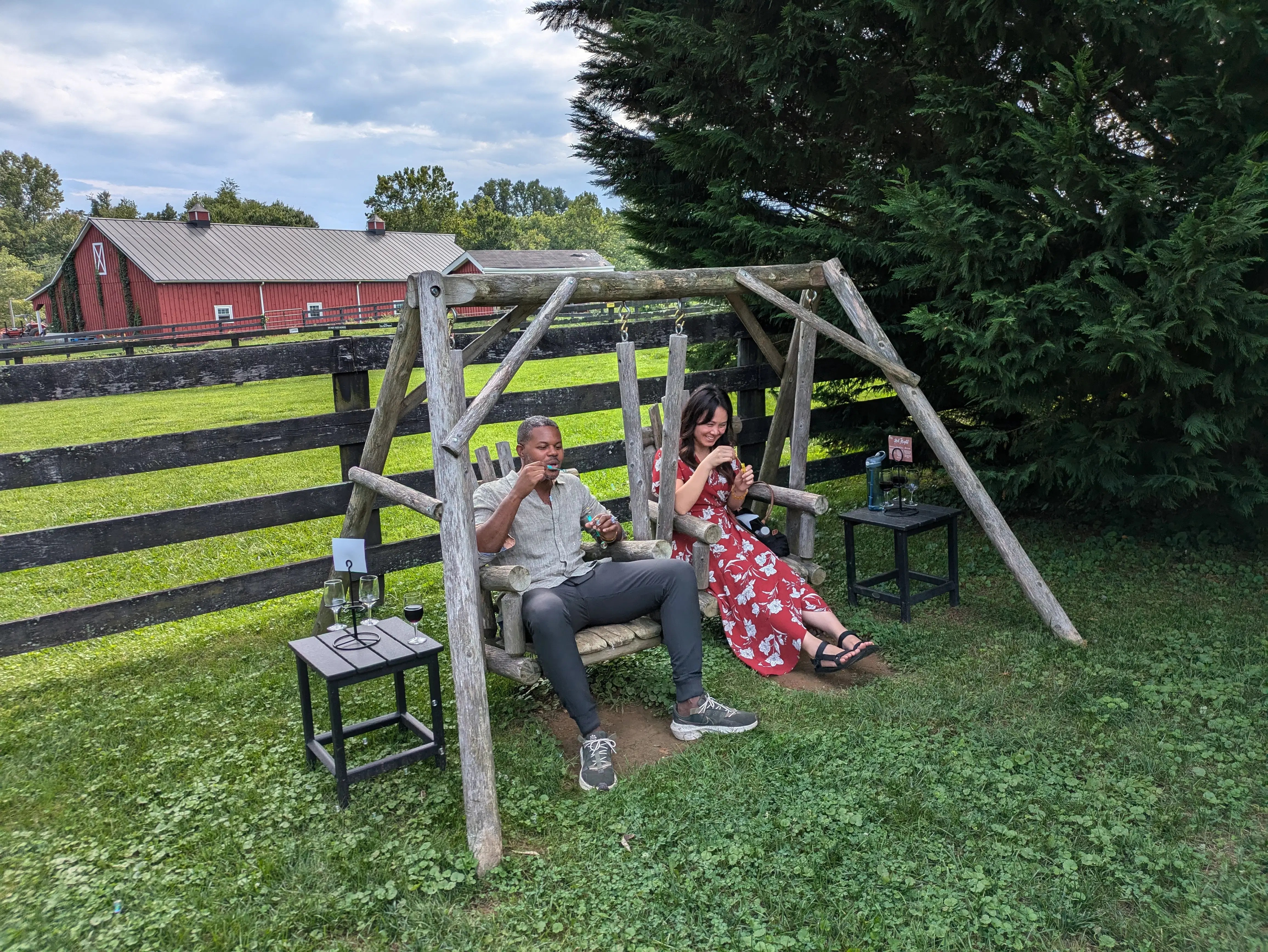 A couple relaxing together in a vineyard setting with wine and pastoral scenery