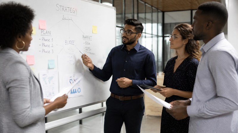 Diverse team of business professionals collaborating around a whiteboard with strategy notes