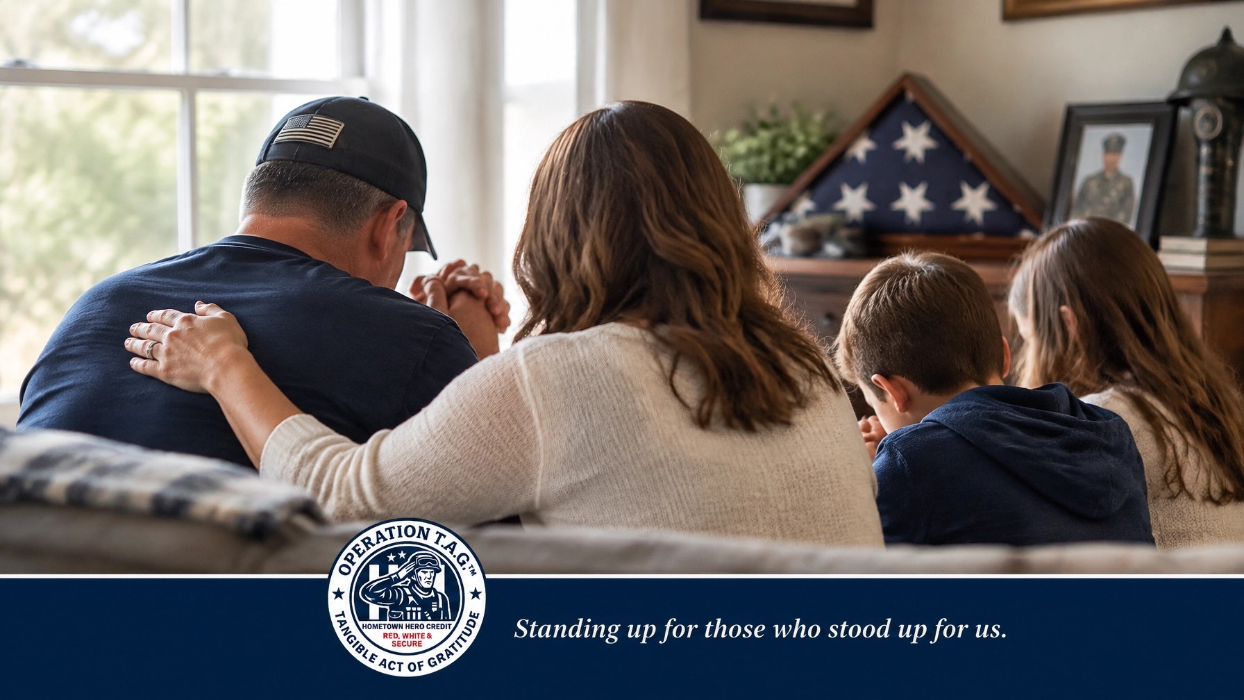 A veteran family seen from behind in a quiet moment of prayer and support at home